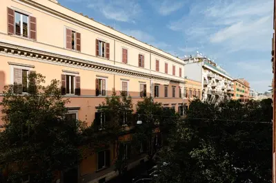 a large white building with trees in front of it at PennyLane Rome Apartment in Rome