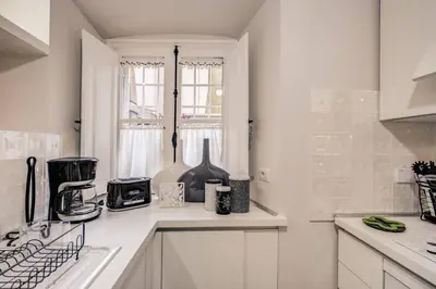 a kitchen with white counters and a window at Flat with terrace by Vatican in Rome
