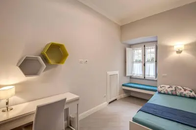 a bedroom with a bed and a desk and a window at Flat with terrace by Vatican in Rome