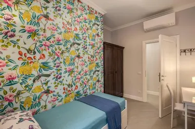 a bedroom with a flowery wallpaper on the wall at Flat with terrace by Vatican in Rome
