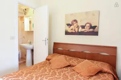 a bedroom with a bed and a painting on the wall at B&B Bel Ami in Rome