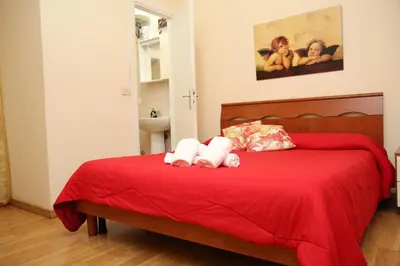 two stuffed animals sitting on a red bed at B&B Bel Ami in Rome