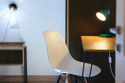a white chair next to a desk with a lamp at THE ROMAN WAY San Giovanni in Rome