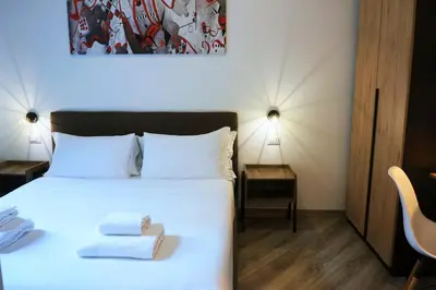 a bedroom with a white bed with towels on it at THE ROMAN WAY San Giovanni in Rome