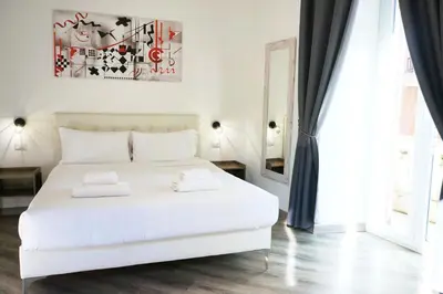 a bedroom with a white bed with two pillows on it at THE ROMAN WAY San Giovanni in Rome