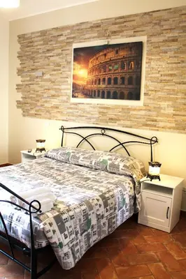 a bedroom with a bed and a picture of the coliseum at 50 Passi Colosseo Apartment in Rome