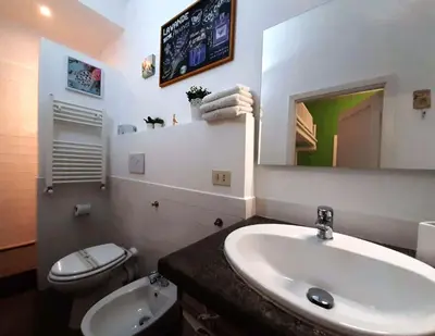 a bathroom with a sink and a toilet and a mirror at 50 Passi Colosseo Apartment in Rome