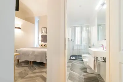 a bathroom with a bed and a sink and a toilet at Eccelso Hotel in Rome