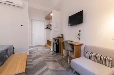 a room with a bed and a desk and a television at Eccelso Hotel in Rome