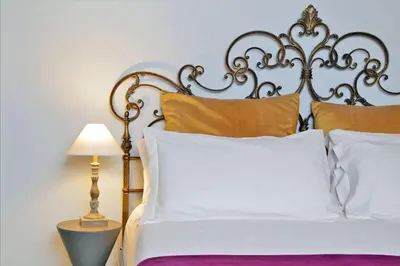 a bed with a metal headboard and pillows at Sangallo Rooms - Residenze Romanae in Rome