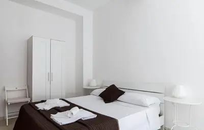 a white bedroom with a bed with towels on it at Al Colosseo 8 in Rome