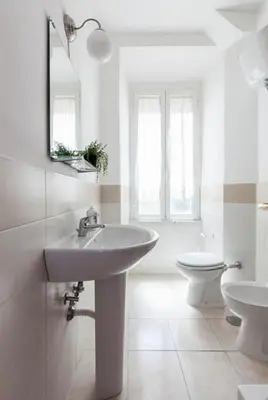 a white bathroom with a sink and a toilet at Al Colosseo 8 in Rome
