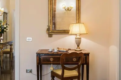 a desk with a chair and a lamp on it at Alta Luxury Apartments - Oca Apartment in Rome