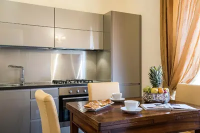 a kitchen with a wooden table with chairs and a tableasteryasteryasteryasteryastery at Alta Luxury Apartments - Oca Apartment in Rome