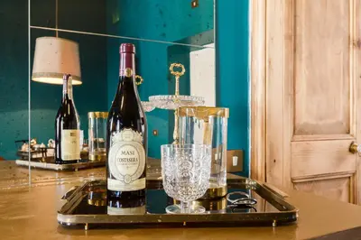 a tray with two bottles of wine and a glass at Glamour Leonina - Monti in Rome