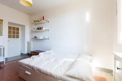 a bedroom with a large bed with white sheets at PIAZZA MAZZINI APARTMENT in Rome