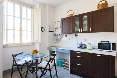 a kitchen with a table and chairs and a microwave at PIAZZA MAZZINI APARTMENT in Rome
