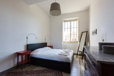a bedroom with a bed and a desk and a sink at PIAZZA MAZZINI APARTMENT in Rome