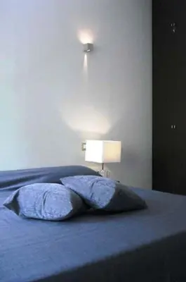 a bed with a blue pillow and a lamp at B&B Il Granello Di Senape in Rome