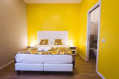 a bedroom with a bed with a yellow wall at Angelina Rooms in Rome in Rome