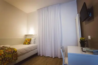 a bedroom with a bed and a desk with a window at Angelina Rooms in Rome in Rome