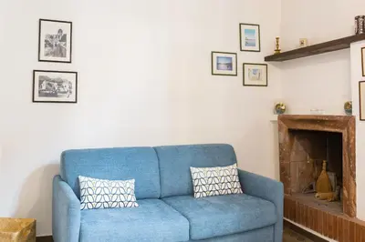 a blue couch in a living room with a fireplace at Sara Apartment - Campo de Fiori 35 in Rome