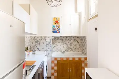 a kitchen with white cabinets and a sink at Sara Apartment - Campo de Fiori 35 in Rome
