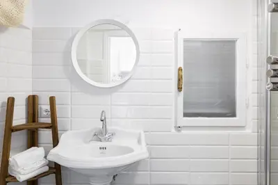 a white bathroom with a sink and a mirror at Sara Apartment - Campo de Fiori 35 in Rome