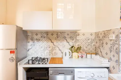 a kitchen with white cabinets and a stove top oven at Sara Apartment - Campo de Fiori 35 in Rome
