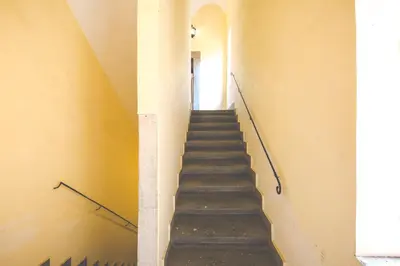 a staircase leading up to a room with yellow walls at Sara Apartment - Campo de Fiori 35 in Rome