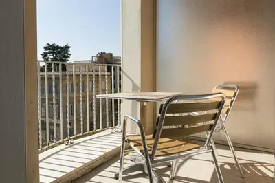 a table and a chair sitting on a balcony at Hotel Casa Valdese Roma in Rome