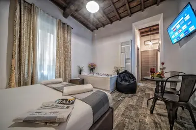 a bedroom with a bed and a tv and a tub at StarHome Navona in Rome