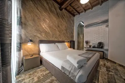a bedroom with a large bed and a brick wall at StarHome Navona in Rome