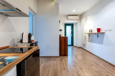 a kitchen with white walls and a wooden counter top at Il Giardino Dell'Argano Rosso in Rome