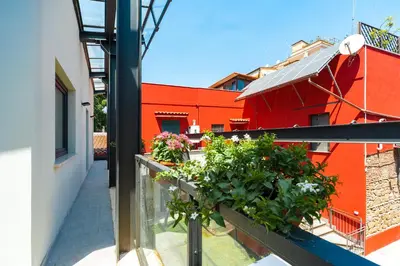 a balcony with plants and a red building at Il Giardino Dell'Argano Rosso in Rome