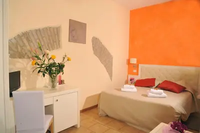 a bedroom with a bed and a desk with a vase of flowers at Locanda al Viminale in Rome