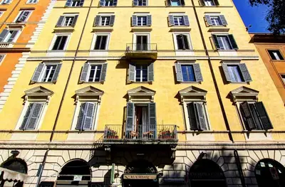 a large yellow building with windows and a balcony at Locanda al Viminale in Rome