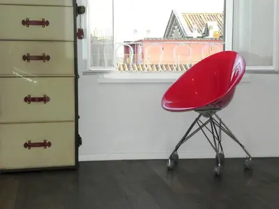 a red chair sitting in front of a dresser at LINE-UP Apartment in Rome