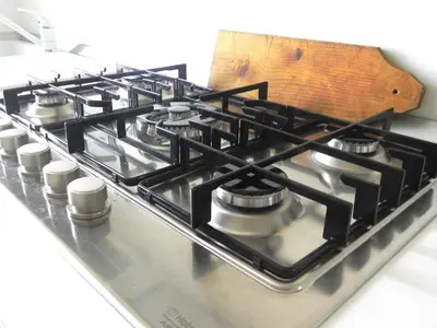 a gas stove top with a wooden cutting board on it at LINE-UP Apartment in Rome