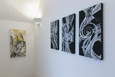 a group of four paintings hanging on a wall at Art Apartment Navona Square in Rome