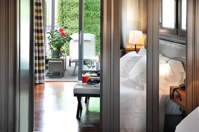a bedroom with a bed and a table next to a window at Hotel Lunetta in Rome