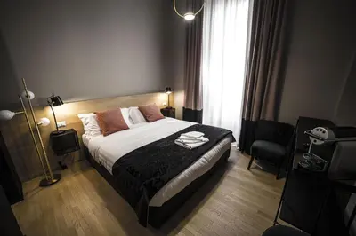 a bedroom with a bed and a chair and a window at SuiteLifeTrevi in Rome