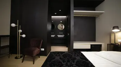 a bedroom with a bed and a chair and a sink at SuiteLifeTrevi in Rome