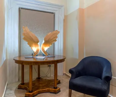 a table with a sculpture of wings on it next to a chair at Le Clarisse Pantheon in Rome