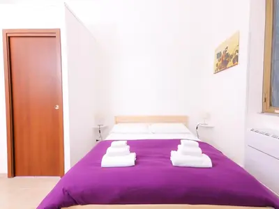 a bedroom with a purple bed with white pillows at Cielo Vaticano Guest House in Rome