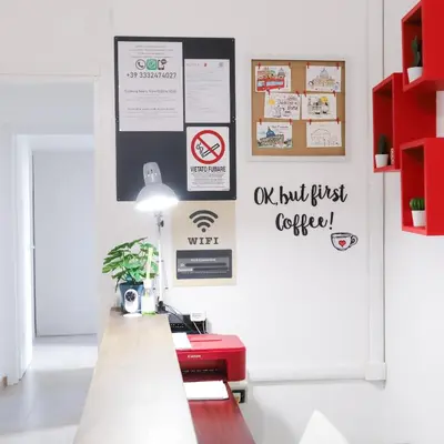 a waiting room with a table and signs on the wall at Cielo Vaticano Guest House in Rome