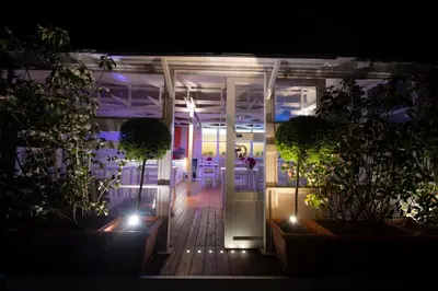 a night view of a room with plants and lights at QuodLibet in Rome