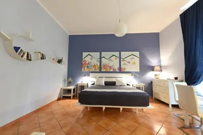a bedroom with a bed and a blue wall at QuodLibet in Rome