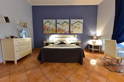 a bedroom with a bed and a blue wall at QuodLibet in Rome