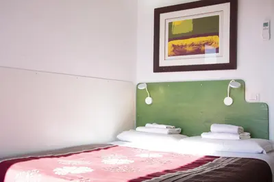 a bedroom with a bed with a green headboard at BEACHBAR Apartment in Rome in Rome